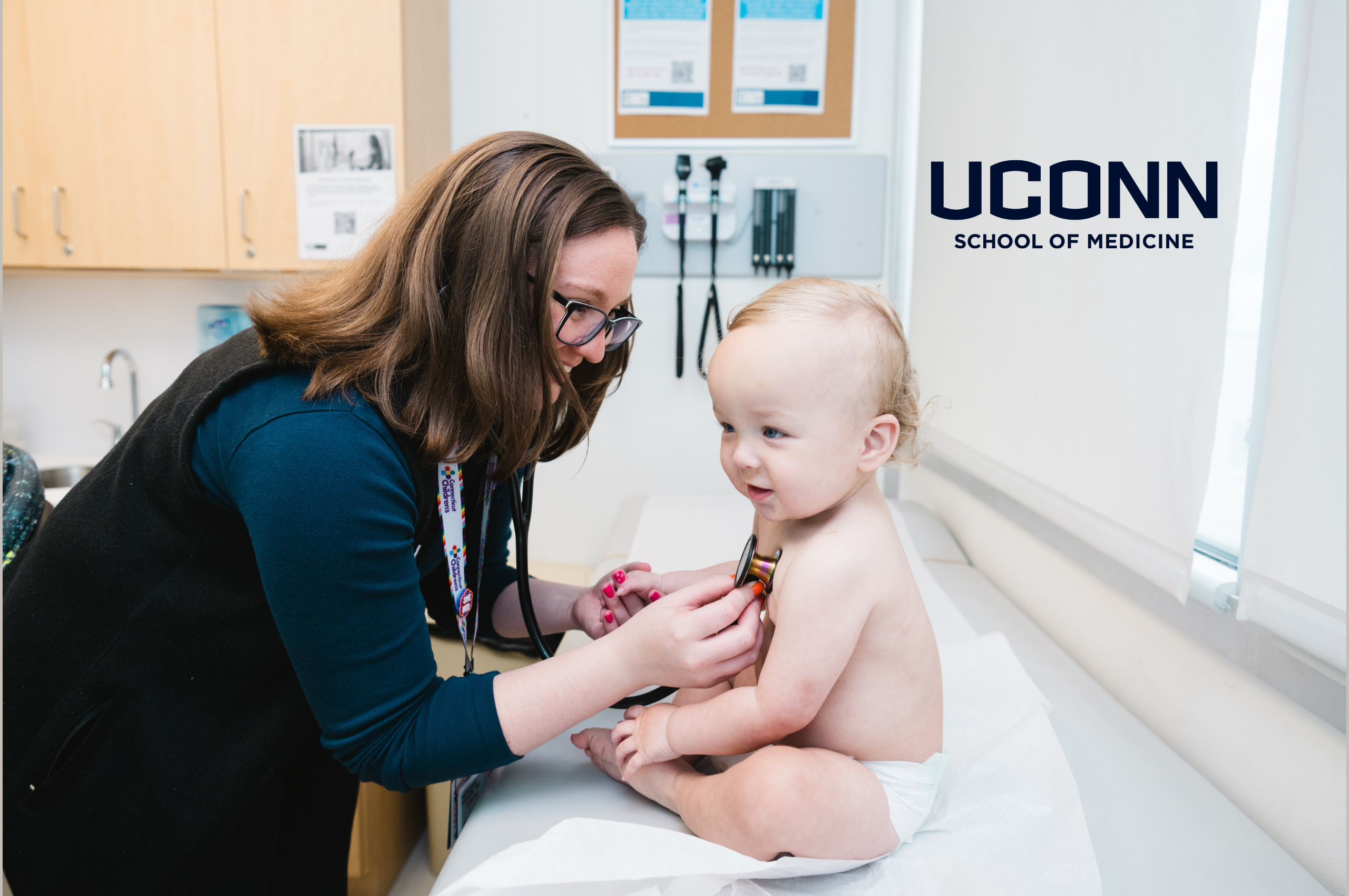 UConn Pediatric resident caring for a baby in exam room
