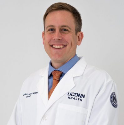 Dr. Benjamin Ristau in his white coat smiling